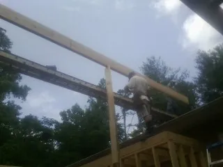 Carpenter setting a ridge beam over a new addition frame — Ice Dam Removal by Roofing Brothers in Juntura