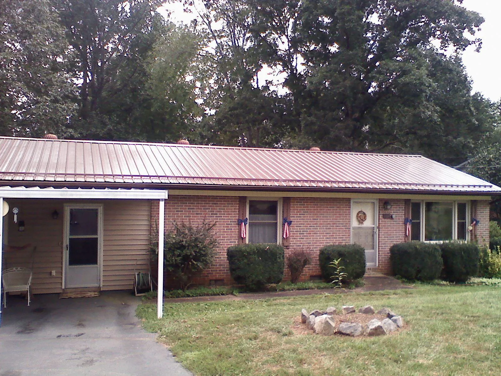 Bronze metal roof and carport on a brick ranch home — Roof Repair work by our crew in Juntura